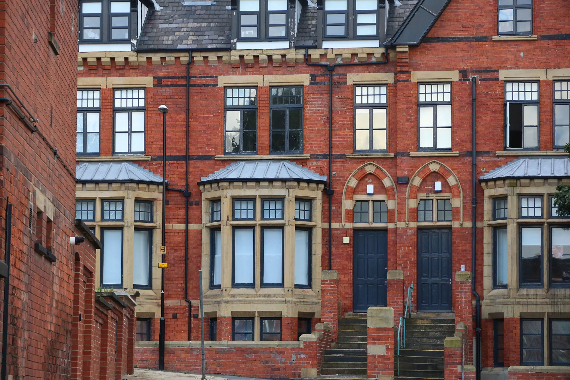 A red brick building with a clock tower in front of it.